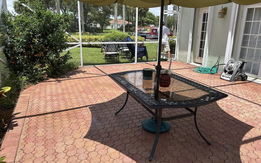 Screened lanai paver deck after cleaning with the patio table and umbrella back in place