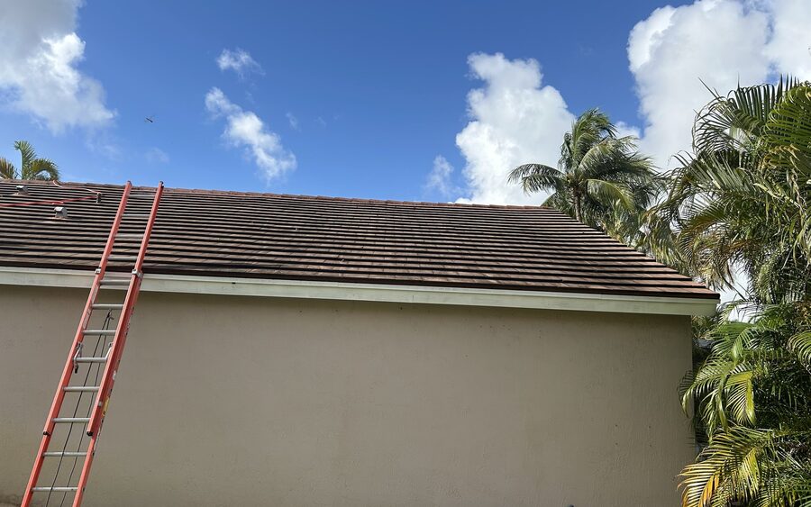 Ladder set against the side slope of a tile roof for soft wash access