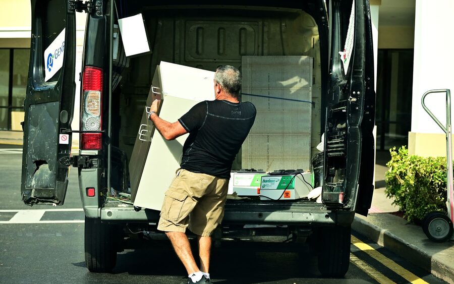 Person lifting a cabinet into the back of an open cargo van