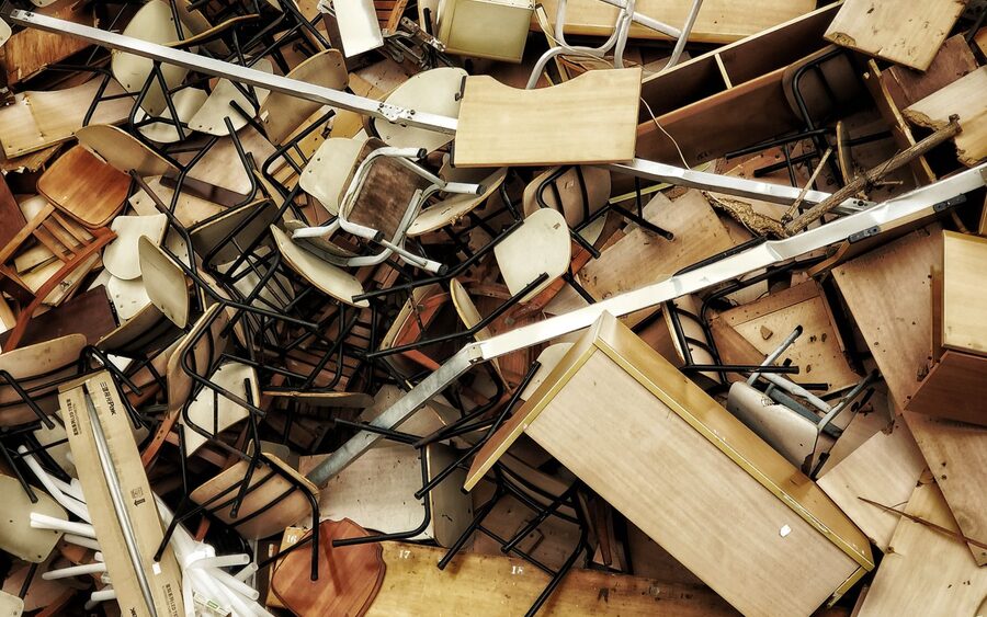 Overhead view of a pile of discarded wooden chairs, tables and timber